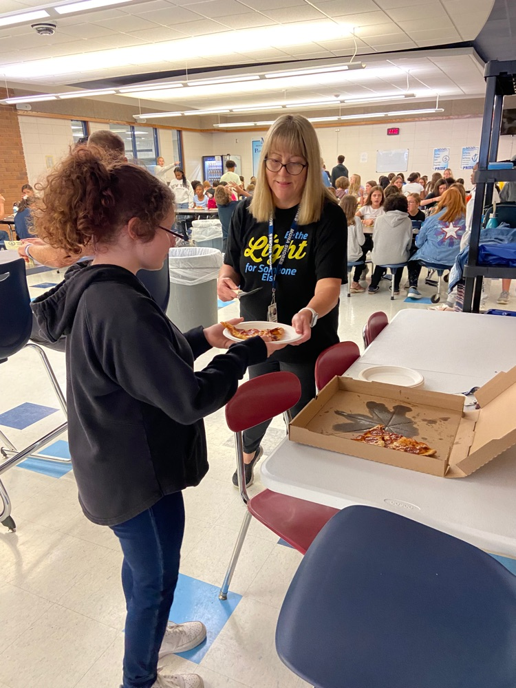 student receiving pizza reward from staff 