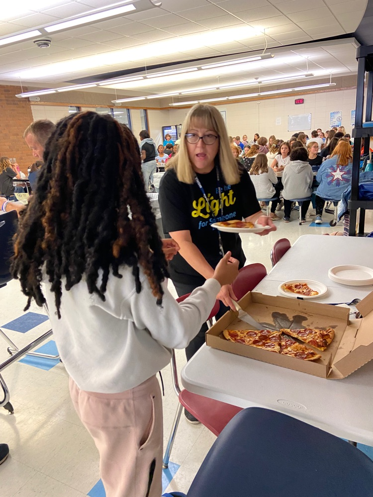student receiving pizza reward from staff