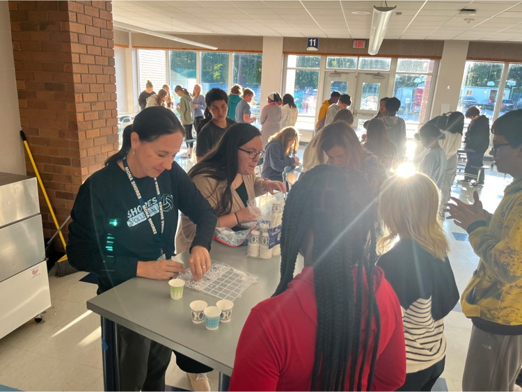 teachers passing out bracelet making materials