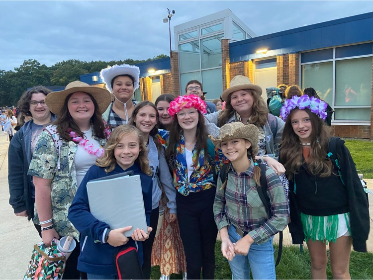 group of students outside wearing cowboy and island attire 